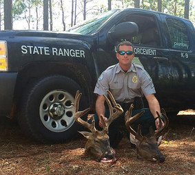 Game warden with two deer heads