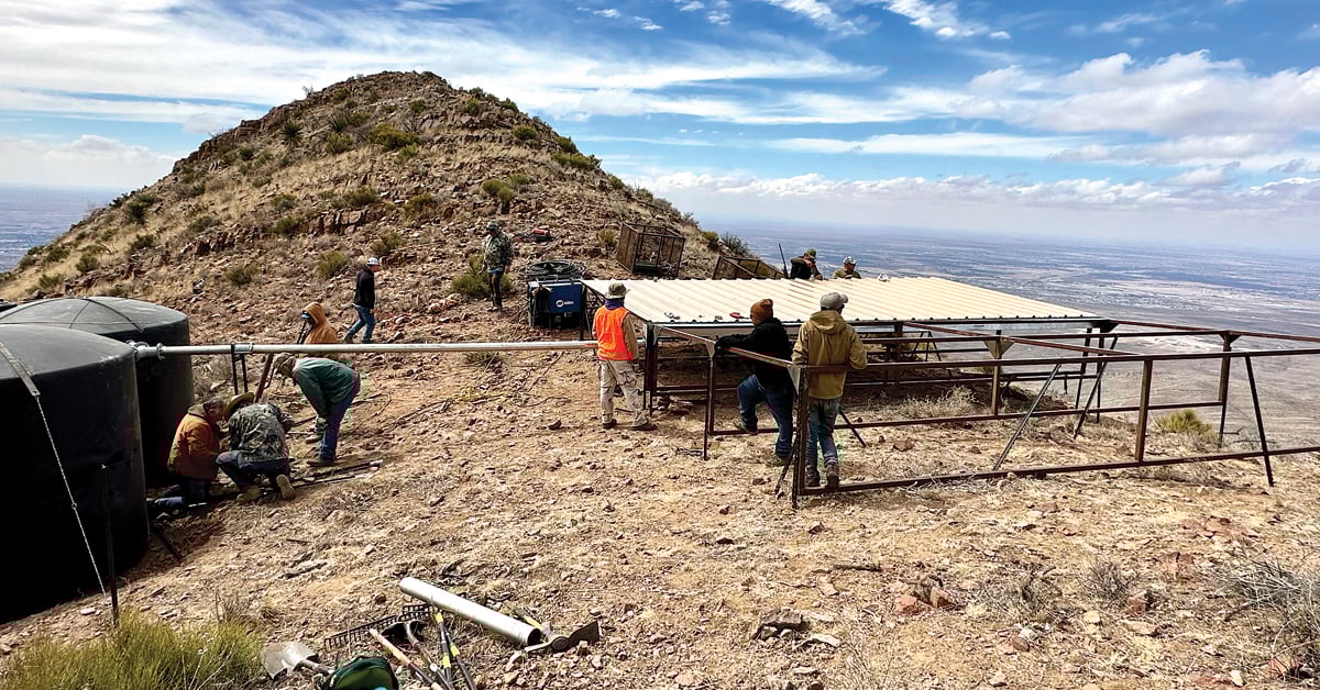 men building platform on mountain